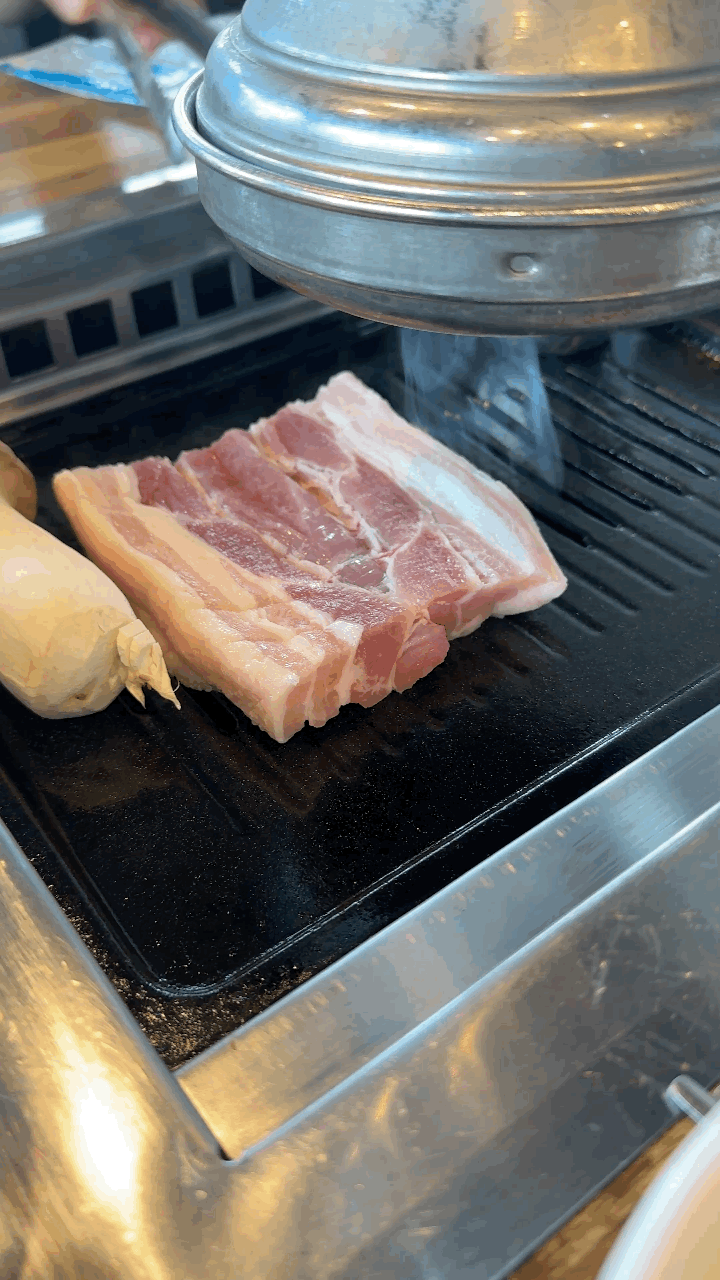 제주 모슬포 생갈비 맛집 상원가든에서 제공되는 두툼한 생갈비 2인분, 불판 위에 올려진 고기의 육즙과 마블링이 선명하게 보이는 모습